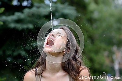 Young woman being splashed with water