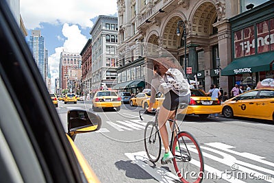 Young woman biking in Manhattan traffic