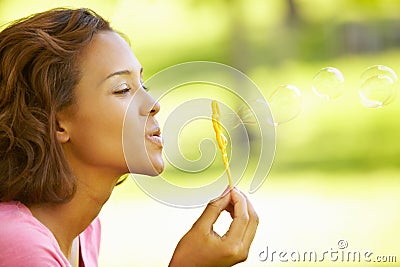 Young woman blowing bubbles