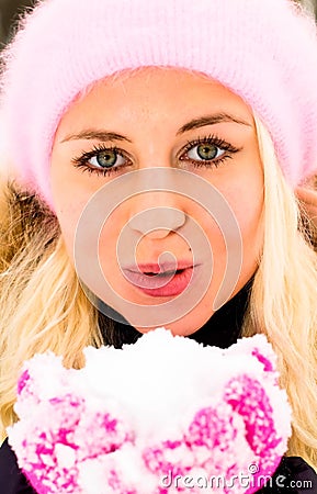 Young woman blowing snow
