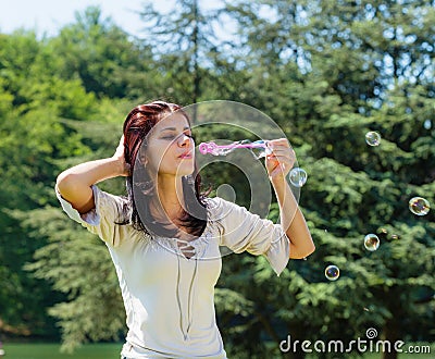 Young woman blowing soap bubbles