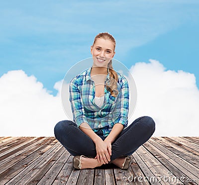 Young woman in casual clothes sitting on floor