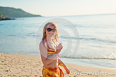 Young woman with cocktail relaxing on beach