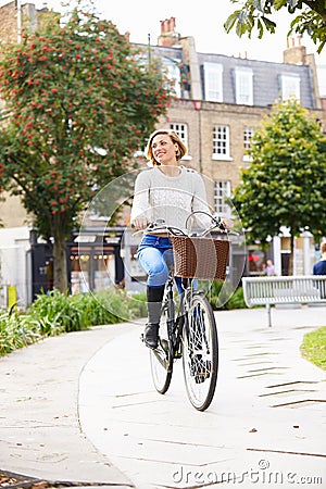 Young Woman Cycling Through Urban Park