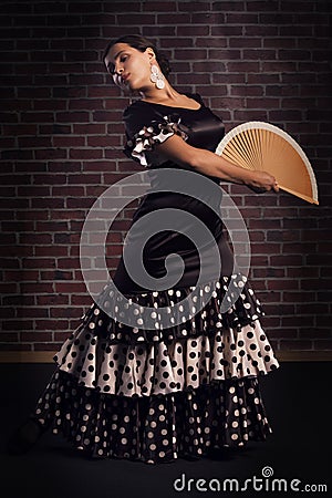 Young woman dancing flamenco with hand fan