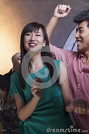 A young woman dancing with friends in a nightclub