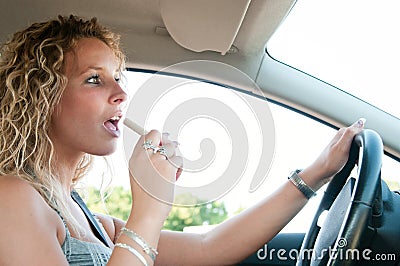 Young woman eating while driving car