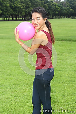 Young woman exercised with pink ball