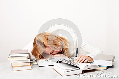 Young woman falling asleep while studying