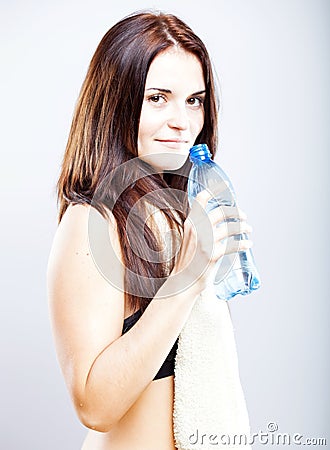 Young woman after fitness with towel and water bottle