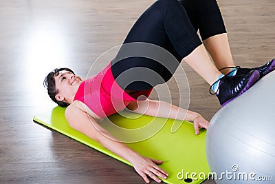 Young woman fitness workout in gym with fitball