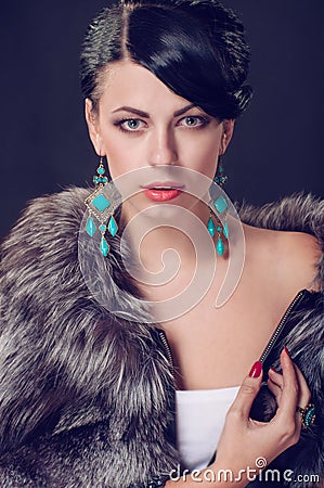 Young woman in a fur coat in earrings