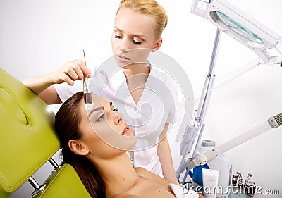 Young woman getting beauty skin mask treatment on her face with