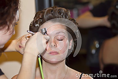Young woman getting makeup done