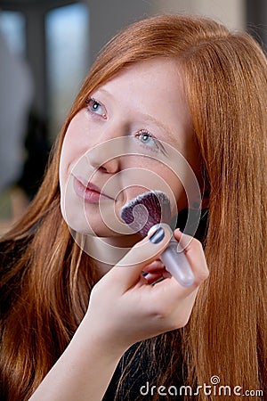 Young woman is getting makeup