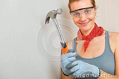 Young woman with hammer in hands
