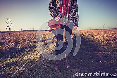 Young woman with handbag standing on nature trail