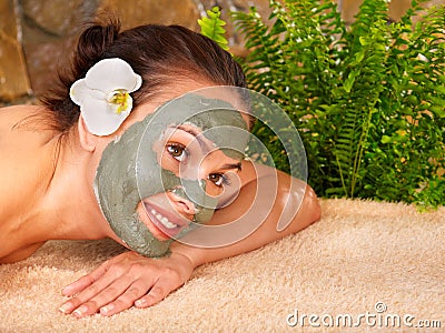 Young woman having clay body mask.