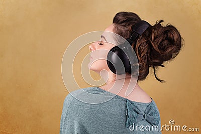 Young woman with headphones listening to music with copy space