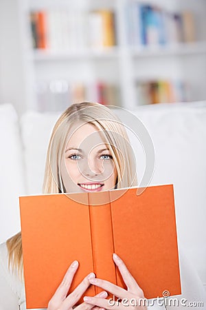 Young Woman Holding Book In Living Room