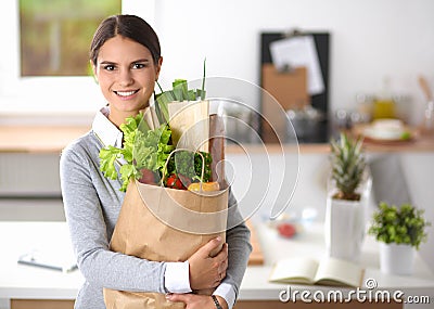 Young woman holding grocery shopping bag with
