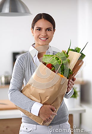 Young woman holding grocery shopping bag with