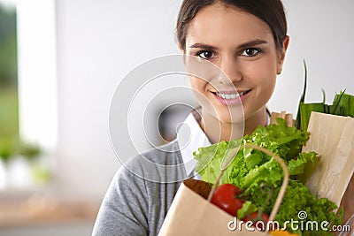 Young woman holding grocery shopping bag with