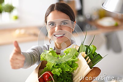 Young woman holding grocery shopping bag with