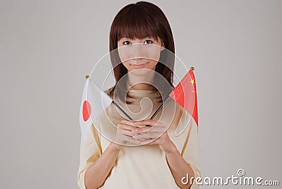 Young woman holding Japanese flag and Chinese flag