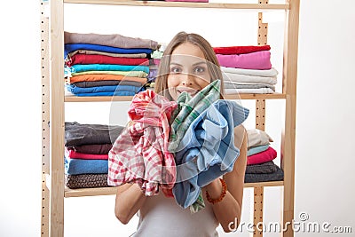 Young woman holding a pile of clothes