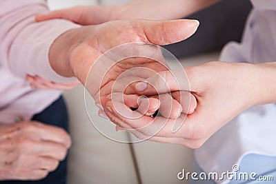 Young woman holding senior woman s hand