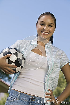 Young Woman Holding Soccer Ball low angle view.