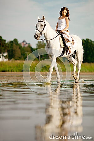 Young woman on a horse. Horseback rider, woman riding horse on b