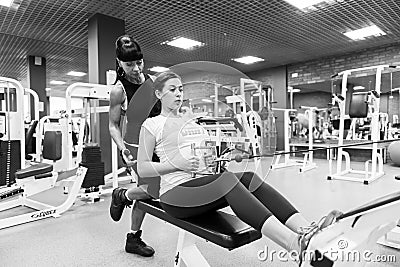 Young woman with an instructor in the gym