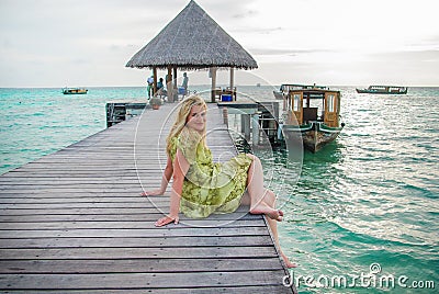 Young woman landing stage on beach on Maldives