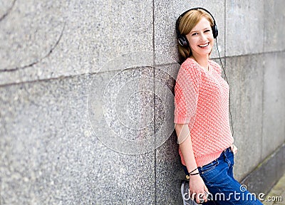 Young woman leaning against wall