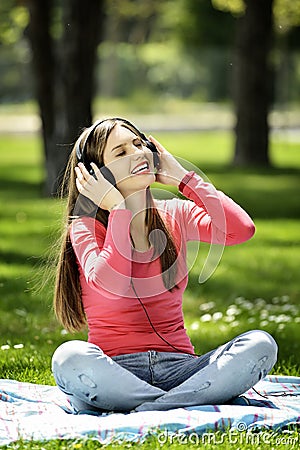 Young woman listening music in nature is my hobby