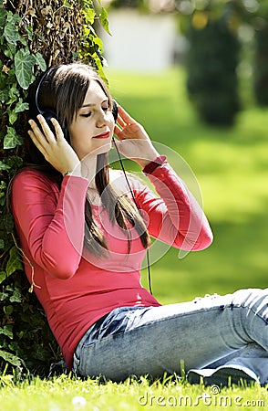 Young woman listening music in nature is my hobby