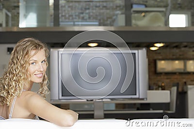 Young Woman In Living Room With Plasma Television In Background