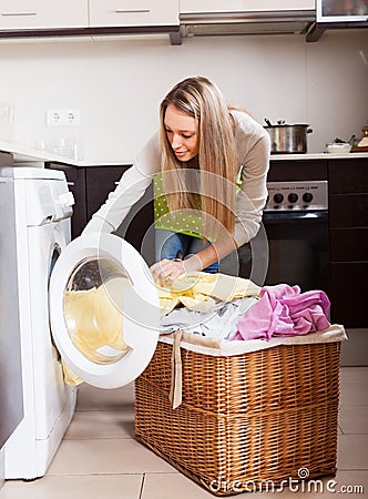 Young woman loading the washing machine