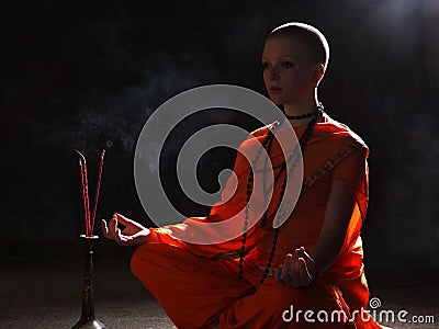 The young woman in orange robers in meditation