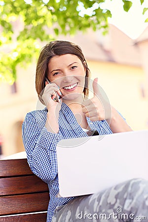 Young woman in park with computer