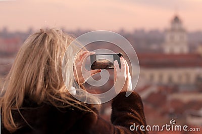 Young woman photographing city of Vilnius