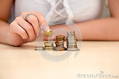 Young woman put coins on coin-stack