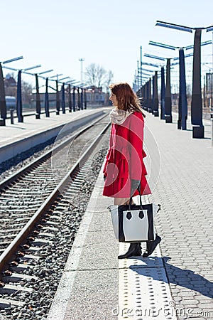 Young woman in red at a train station