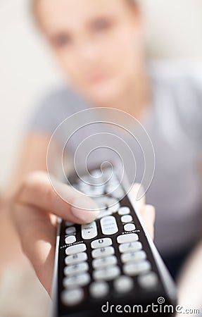 Young woman with remote watching TV.