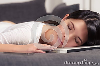 Young woman resting her head on a laptop