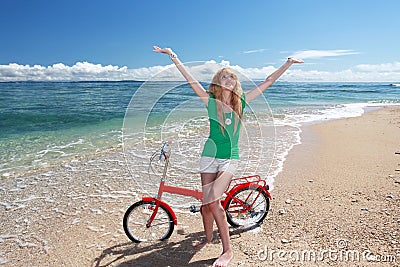 Young woman riding a bicycle on the beach