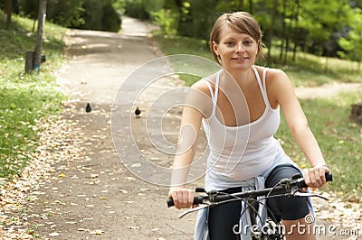 Young woman riding with bike