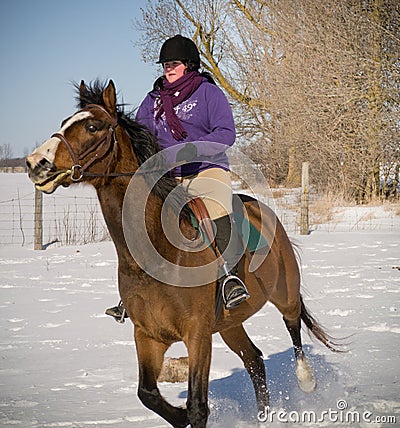 Young Woman riding horse in winter